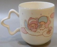 a white coffee cup with two little angels on it