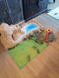 a fake volcano is on the floor next to a fireplace