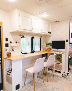 the interior of a mobile home with two desks and chairs in front of it