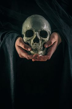 a person holding a skull in their hands