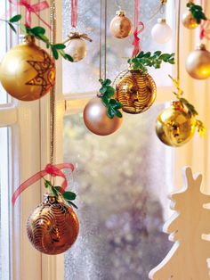 christmas ornaments hanging from a window sill