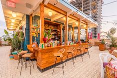 an outdoor bar with lots of chairs and tables