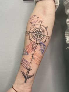 a person's arm with a compass tattoo on it