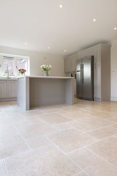 a large kitchen with a center island and stainless steel refrigerator freezer in the middle