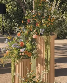 three wooden planters with flowers and plants growing out of them