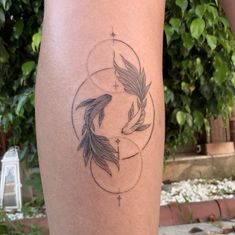 a woman's leg with a tattoo on it that has two birds in the center