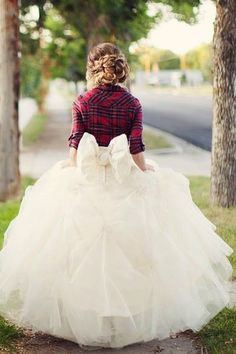 a woman is walking down the street in a dress with a big bow on it