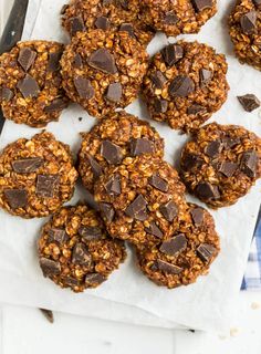 chocolate chip cookies are arranged on top of parchment paper