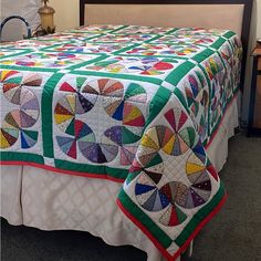 a bed with a colorful quilt on top of it