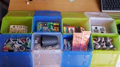 several plastic bins filled with different types of items on a wooden table next to a keyboard