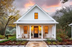 a small white house with two windows on the front and one door open to let in light