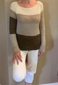 A soft luxurious woman's sweater in all natural limited Alpaca yarn.   The neck line and wrists have a textured pattern for added       interest.  The sweater was knit top down seamlessly no annoying seams  to worry about.  I choose a limited alpaca yarn and all natural earth tones from cream color  to dark  espresso.brown This woman's sweater is a one of a kind , I never make the same item twice, it's perfect to wear to work in an office setting to stay warm it is casual enough to wear   with jeans and boots.  It is a very comfortable loosefitting size small sweater and since it's made with alpaca yarn it is comfortable to wear against your skin. The length of the long sleeves are 29 inches measured from the neck to the cuff, the whole sweater is 23 inches long from the neck to the hem, a Casual Alpaca Sweater With Knitted Details, Cozy Hand Knitted Alpaca Sweater, Winter Alpaca Soft Knit Sweater, Brown Alpaca Long Sleeve Sweater, Hand-knitted Alpaca Cozy Sweater, Small Sweater, Yarn Store, Alpaca Yarn, Pullover Sweater Women