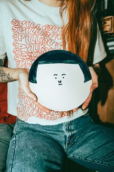 a person holding a white object with a face drawn on it