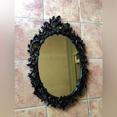 a round mirror sitting on top of a tiled floor