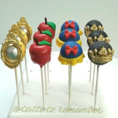 there are six cake pops with different designs on them, each decorated like an apple