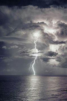 a storm is coming over the ocean and it appears to be lightning striking in the sky