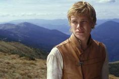 a young man standing on top of a mountain