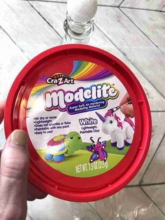 someone is holding up a plastic container with white stuff in it and the lid has an image of a unicorn on it