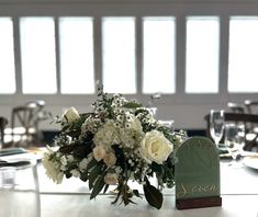 there is a vase with white flowers on the table at this wedding reception in an elegant setting