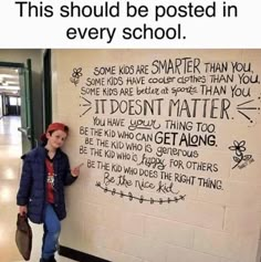 a person standing in front of a wall with writing on it that says, this should be posted in every school