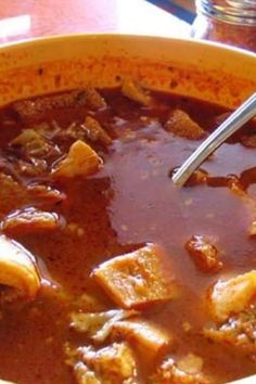 a yellow bowl filled with meat and vegetable soup