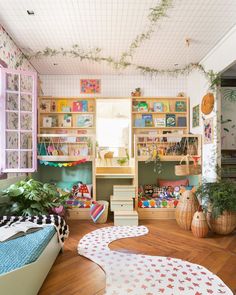 a room filled with lots of plants and bookshelves next to each other on shelves