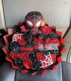 a spiderman birthday cake with roses in the center