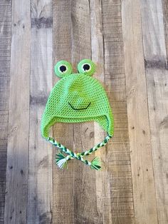 a green frog hat on top of a wooden floor