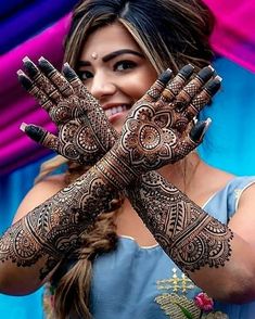 a woman holding her hands up with henna on it