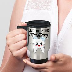 a woman holding a travel mug with a tooth on it