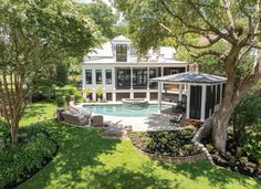 an aerial view of a house with a swimming pool and patio in the foreground