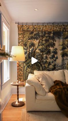 a living room filled with furniture and a tapestry on the wall