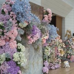 there are many different colored flowers on the wall and in the background is a stuffed animal