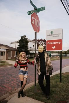 a man and woman standing next to a stop sign