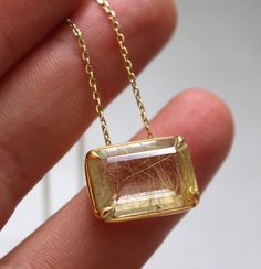 Unique rectangular rutiled quartz pendant set in gold-plated silver setting. The chain is gold-plated silver. Stone: Rutiled quartz  Chaine: 43cm Material: Gold-plated silver To see more necklaces, follow this link: https://www.etsy.com/shop/AtelierTiuh?section_id=27795402 Do not hesitate to contact me with any questions. Gold Faceted Rectangular Pendant Jewelry, Gold Faceted Necklace With Rectangular Pendant, Gold Necklace With Faceted Rectangular Pendant, Gold Faceted Rectangular Stone Jewelry, Gold Faceted Jewelry With Rectangular Stone, Gold Faceted Rectangular Necklace, Gold Rectangular Faceted Necklace, Rectangular Gold Necklace With Gemstone, All That Glitters