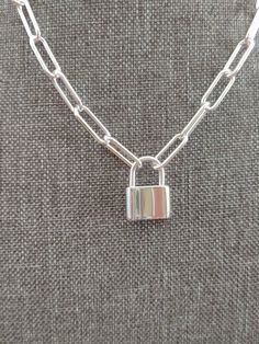 This sterling silver push clasp features a padlock pendant with spring-loaded hinge. To use simply pull  on the top part of the padlock for putting it on or taking off the strand. Dimensions: 20 x 14 mm (large). Please look at life pictures, it's has all dimensions, shows on mannequin, in my hand and etc.  Paperclip chain comes in any length. Choose yours. We offer professional engraving services. We can engrave with letters, monograms. Leave your message in the instruction window. Solid Sterling Silver Paperclip Cable Chain Link size: 6mm wide x 15.5mm long. Very sturdy and thick.  Note Not returnable if engraved including chain. We only engrave in regular font or italic. Specify yours at checkout. Default is regular font. Thank you for visiting! Sterling Silver Lock Necklace, Silver Lock Necklace In Sterling Silver, Everyday Silver Lock Jewelry, Everyday Silver Necklace With Lock Detail, Silver Paperclip Necklace, Paper Clip Necklace, Paperclip Necklace, Life Pictures, Paper Clip