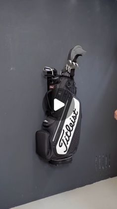 a golf bag hanging on the wall next to a putter's club holder