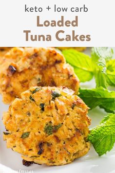 two crab cakes on a plate with mint leaves in the background and text overlay reading onion & herb tuna cakes keto, low carb