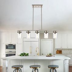 three stools sit at the center of a kitchen island