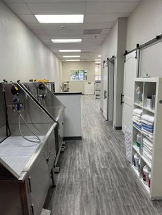 an empty hospital hallway with lots of medical supplies on the shelves and in storage bins