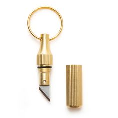 a gold colored keychain with a small metal object on it's side