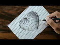 someone is drawing a heart on a piece of paper