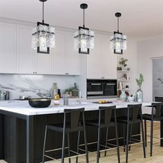 a kitchen with white cabinets and black bar stools