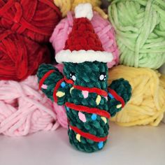 several balls of yarn and a knitted toy in the shape of a christmas tree