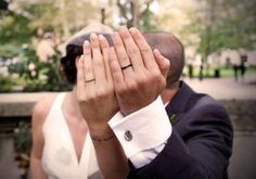 a man in a suit and tie holding his hands up to his face as he looks into the distance