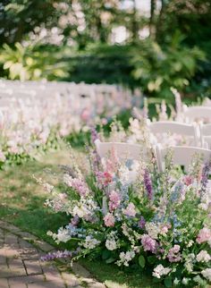 an outdoor ceremony with chairs and flowers