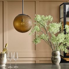 a vase filled with flowers sitting on top of a table next to two wine glasses