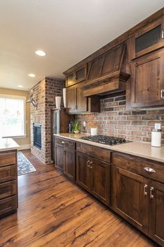 a large kitchen with wooden cabinets and white counter tops, along with hardwood flooring