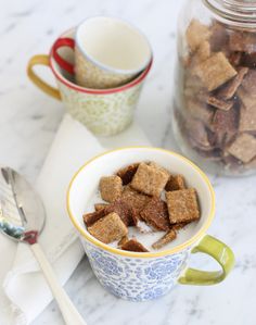 two cups filled with cereal next to a spoon