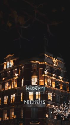 a building lit up at night with the words harvey and nicholas on it